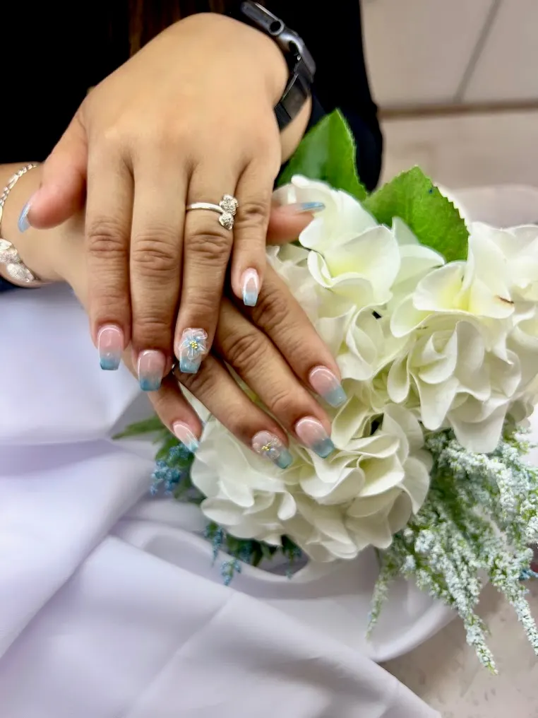 Romantic nude and pink bridal nails with delicate white flowers